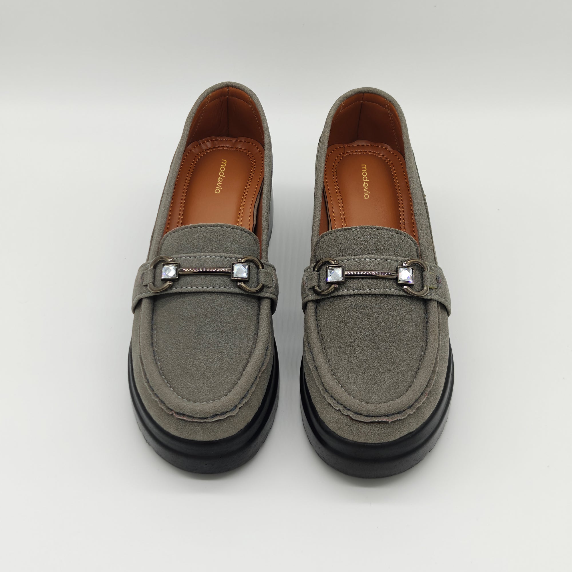 Pair of gray loafers with decorative buckles on a white background