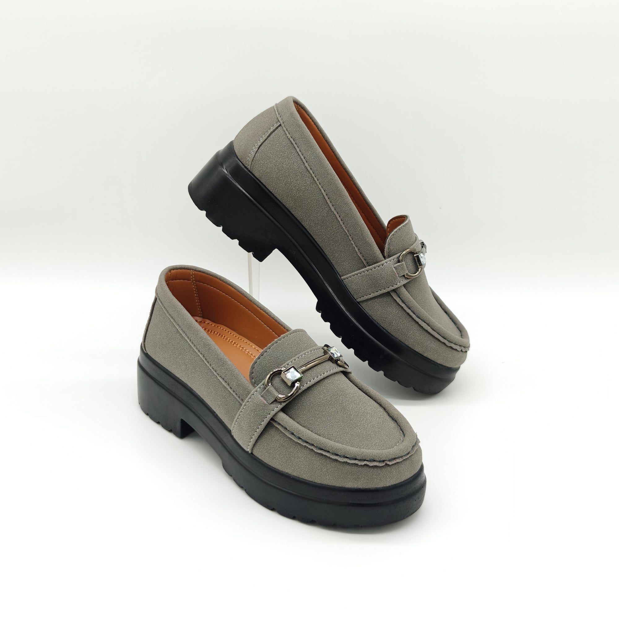 Pair of gray loafers with black soles on a white background